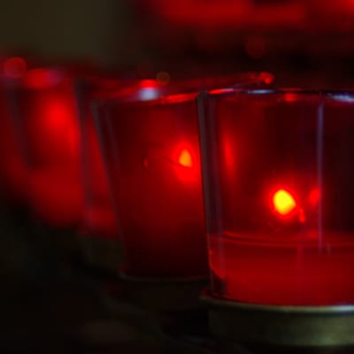 Offertory candles glowing red in the sanctuary